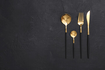 Naklejka premium Beautiful cutlery set on black table, flat lay. Space for text