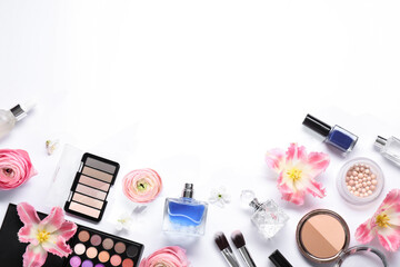 Flat lay composition with different makeup products and beautiful spring flowers on white background, space for text