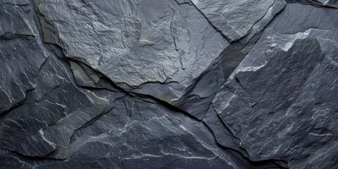 A close up of a rock wall with a grey and black color scheme