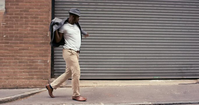 Man, dancing in city and happy with fun music and excited in outdoor, funny and joyful in weekend. African, celebrating and town with humour, playful and goofy in urban background, victory and comic