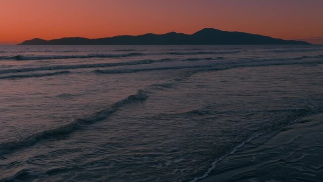 Aerial: Sunset over ocean looking out to Kapiti Island. Paraparaumu, Wellington, New Zealand.