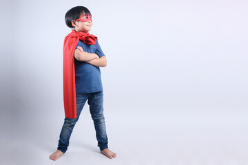 Full Length Portrait of Asian Boy Wearing Superhero Costume Confidently Isolated on Gray Background
