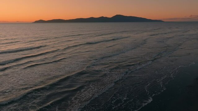 Aerial: Paraparaumu beach and Kapiti Island at sunset, wellington, New Zealand.