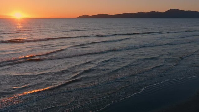 Aerial: Paraparaumu beach and Kapiti Island at sunset, wellington, New Zealand.