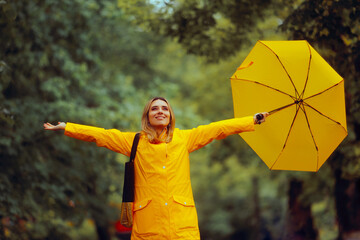 Happy Woman Enjoying Rainy Season Walking Outdoors. Carefree lady feeling enthusiastic about a...