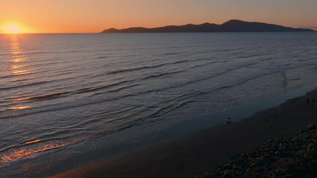 Aerial: Paraparaumu beach and Kapiti Island at sunset, wellington, New Zealand.