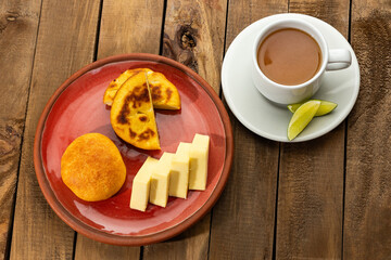 Breakfast served at the table - Arepa, almojabana, cheese and hot aguapanela. Colombian gastronomy