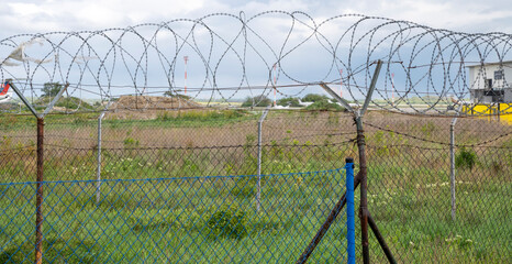 Barbed wire fence. Razor wire. Restricted area. Airport protection.