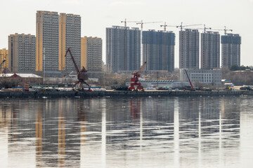 Construction of multi-storey residential buildings on the banks of the Amur River. Heihe, China. River port berth. The Chinese city of Heihe is located on the border with Russia. - 795971305