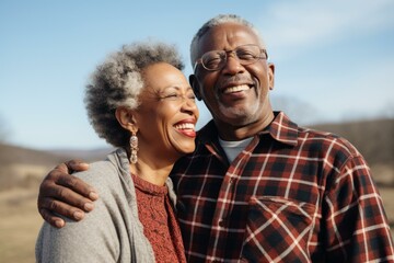 b'Happy elderly African American couple smiling outdoors'