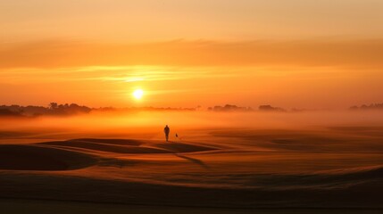Fototapeta na wymiar A breathtaking sunrise casting an orange glow over a pristine golf course with a lone golfer walking towards the first tee