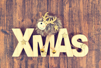 Christmas holidays background. Merry Christmas wording and reindeer on wooden background