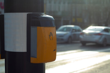 Street photo. Yellow device for switching traffic light signal on pole in front of pedestrian...
