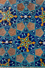 Vertical photo. Close up of fragment of blue-yellow geometric pattern of wall of Motley Bath in Tbilisi with flower, star. Mandala. Georgia. Concept of architecture, real estate agency, rent apartment