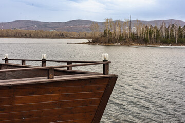 Wooden embankment in the form of a wooden ship with the view of the river, hills and islands