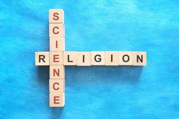 Science and religion relationship and interconnection concept. Crossword puzzle flat lay in blue...