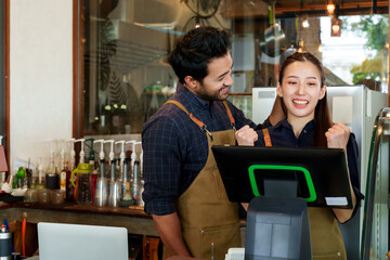 Indian man pointing at screen at take-out machine, showing girlfriend ordering There are many...