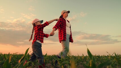 Happy farmers, mom, daughter go field, holding hands. Child, kid points to sunset. Little girl,...