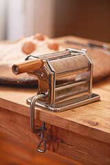 Cooking, dough and pasta maker in kitchen on table, counter and wooden board for cuisine. Food,...