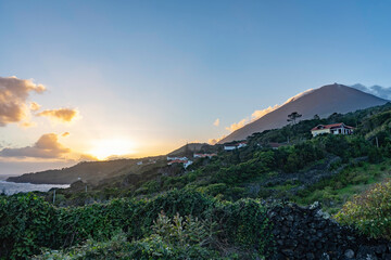 Azores. Pico Island. Beautiful amazing landscape. Pico volcano in the clouds at golden sunset. Sun...