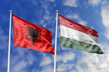 3d illustration. Albania and Hungary Flag waving in sky. High detailed waving flag. 3D render. Waving in sky. Flags fluttered in the cloudy sky.