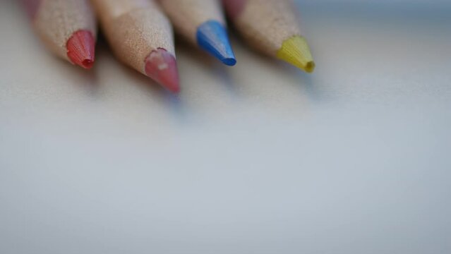 Colored pencil tips lying on a white piece of paper