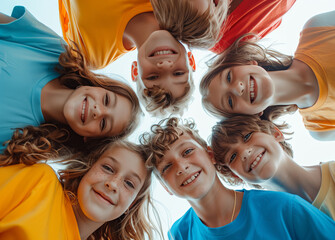 User.A group of happy smiling children hugging each other, looking down at the camera from the ground against a white background