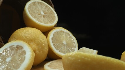 Close up of lemon slices are meticulously arranged against a rustic basket backdrop on a deep black...
