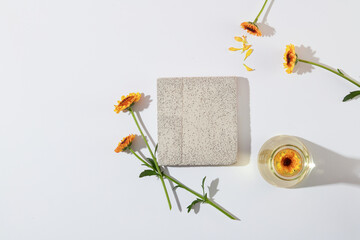 Blank white background with gray brick podium decorated and fresh calendula flowers for cosmetic...