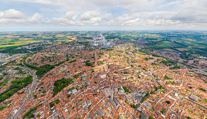 Bruges, Belgium. City center and surroundings. Residential and industrial areas. Panorama of the city. Summer day, cloudy weather. Aerial view