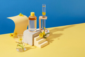 Mockup scene with empty bottle for cosmetics of calendula extract on blue and yellow background....