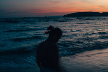 silhouette of woman at beach at dusk