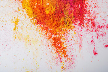 Multicolored mixed holi powder scattered on white background.