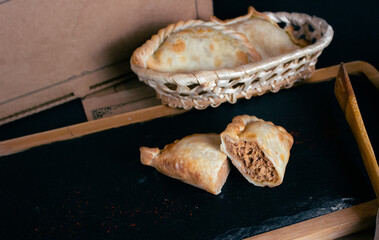 Argentinian Barbecue Empanada on a slate plate, cut in half, lots of filling, little dough
