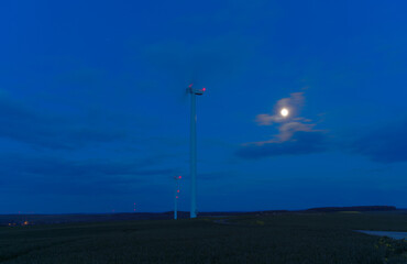Obraz premium Eolienne de nuit devant la lune