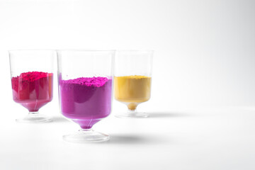 Multicolored holi powder in a glass isolated on white background. Holi powder is a traditional Indian Festival.