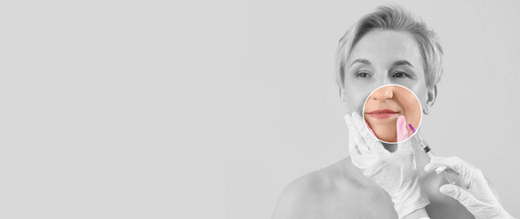 Mature woman receiving lip filler injection on pink background, closeup