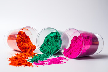 Colorful holi powder in a glass container isolated on white background.
