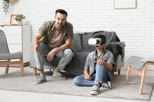 Father and his little son in VR glasses having fun at home