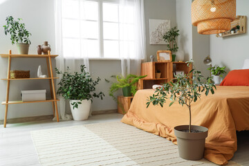 Interior of bedroom with green plants, bed and shelf units
