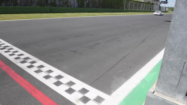 Motorsport signal, green flag waving for blurred cars on finish line straight racetrack, original engine sound