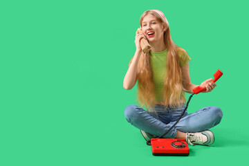 Young woman with doner kebab and telephone on green background