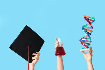 Female hands holding filled flask with graduation hat and DNA model on blue background. Chemistry...
