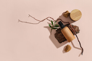 Composition with bottle and jar of cosmetic products and tree bark on beige background