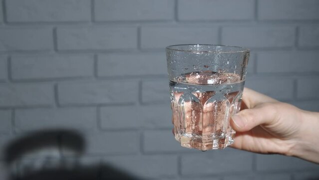 Lady prevent dehydration with glass of water. A woman takes a glass of cold water to prevent the dehydration at hom