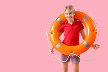 Happy little boy lifeguard with ring buoy on pink background