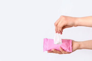 Female hands with pack of wet tissues on white background