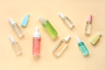 Many different bottles of sanitizers on pale yellow background