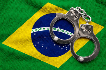 Flag of Brazil and police handcuffs. Crime and offenses in country Concept
