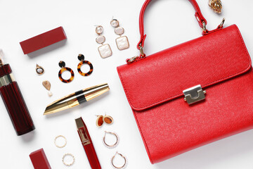 Fototapeta premium Red leather bag, bottle of perfume and beautiful jewellery on white background